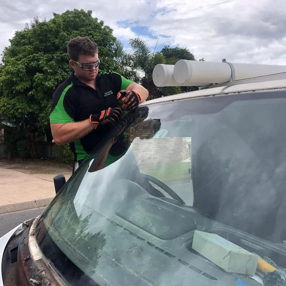 Express Auto Glass fitter removing a windscreen at the kerb outside a customer’s home